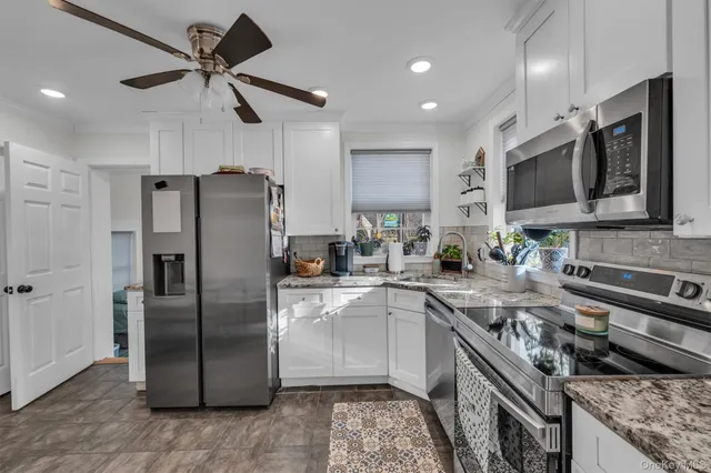 a kitchen with stainless steel appliances granite countertop a refrigerator a sink a stove a microwave and island