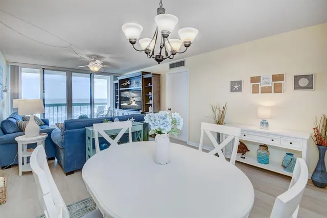 a view of a dining room with furniture a livingroom and chandelier