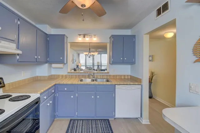 a kitchen with a sink a stove and cabinets