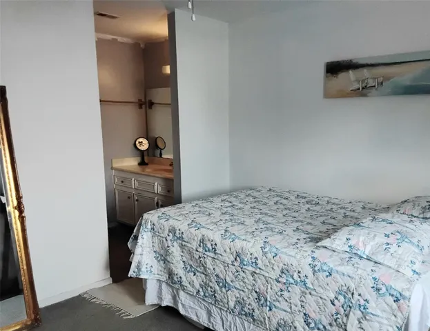 a bathroom with a granite countertop sink a toilet and a mirror
