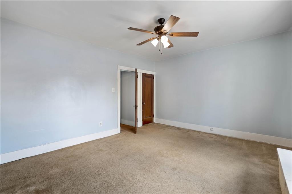 1436 Davis Avenue Pittsburgh, PA 15212 - Photo 22 of 29 an empty room with a chandelier fan and a ceiling fan