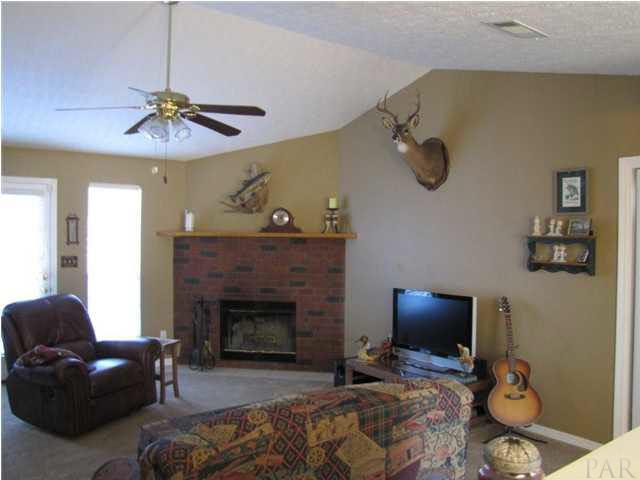 4064 Stoddard Road Pensacola, FL 32526 - Photo 9 of 24 Living room is complete with a brick fireplace to enjoy during our cooler winter months.