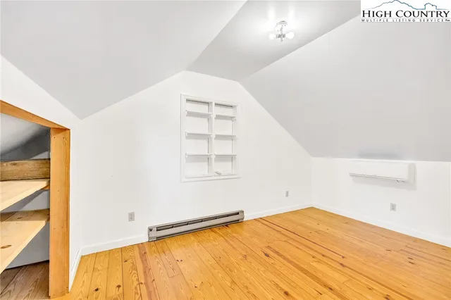a view of a room with wooden floor and white walls