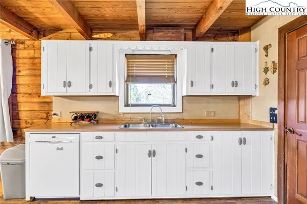 a kitchen with white cabinets and window