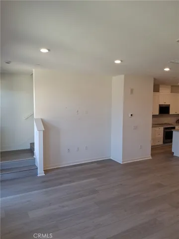 an empty room with wooden floor and a ceiling fan