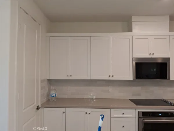 a kitchen with granite countertop white cabinets and stainless steel appliances