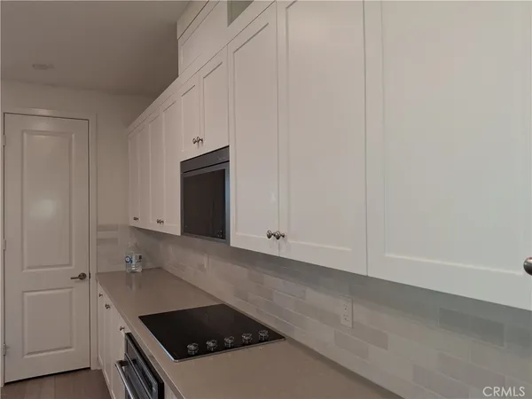 a kitchen with white cabinets and a stove