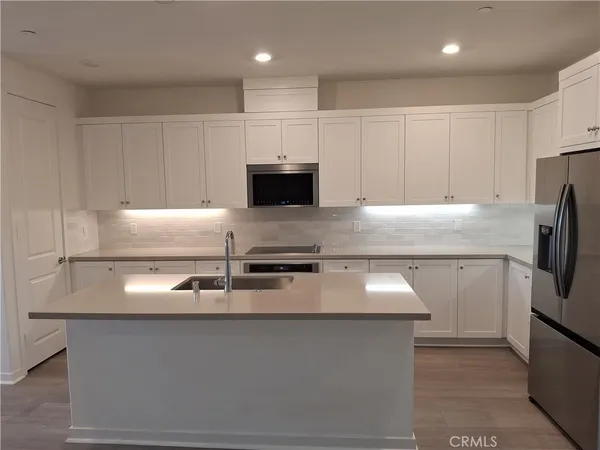a kitchen with granite countertop stainless steel appliances and a sink refrigerator stove
