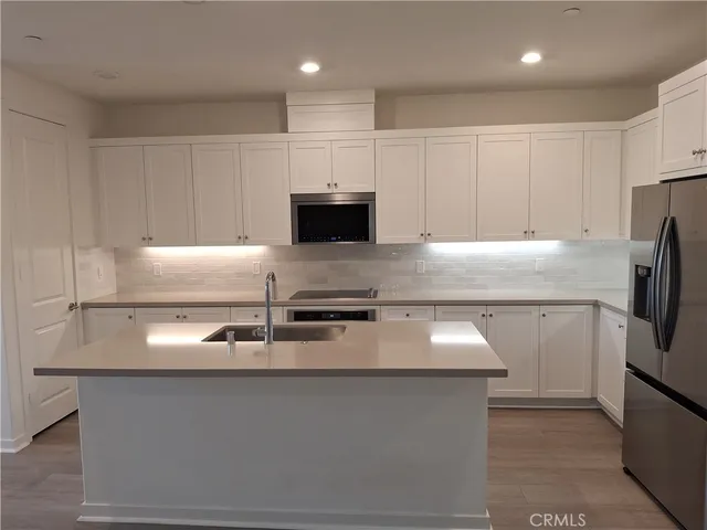 a kitchen with granite countertop stainless steel appliances and a sink refrigerator stove
