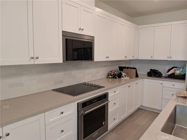 a kitchen with granite countertop white cabinets and stainless steel appliances