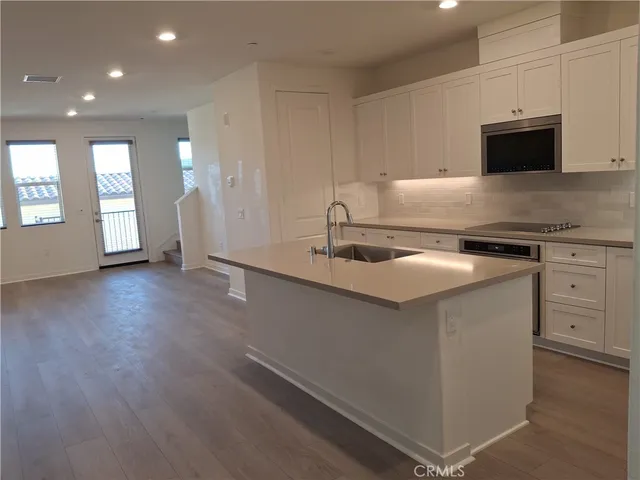 a kitchen with stainless steel appliances granite countertop a sink a stove and a microwave