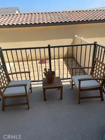 a roof deck with a couch and wooden floor