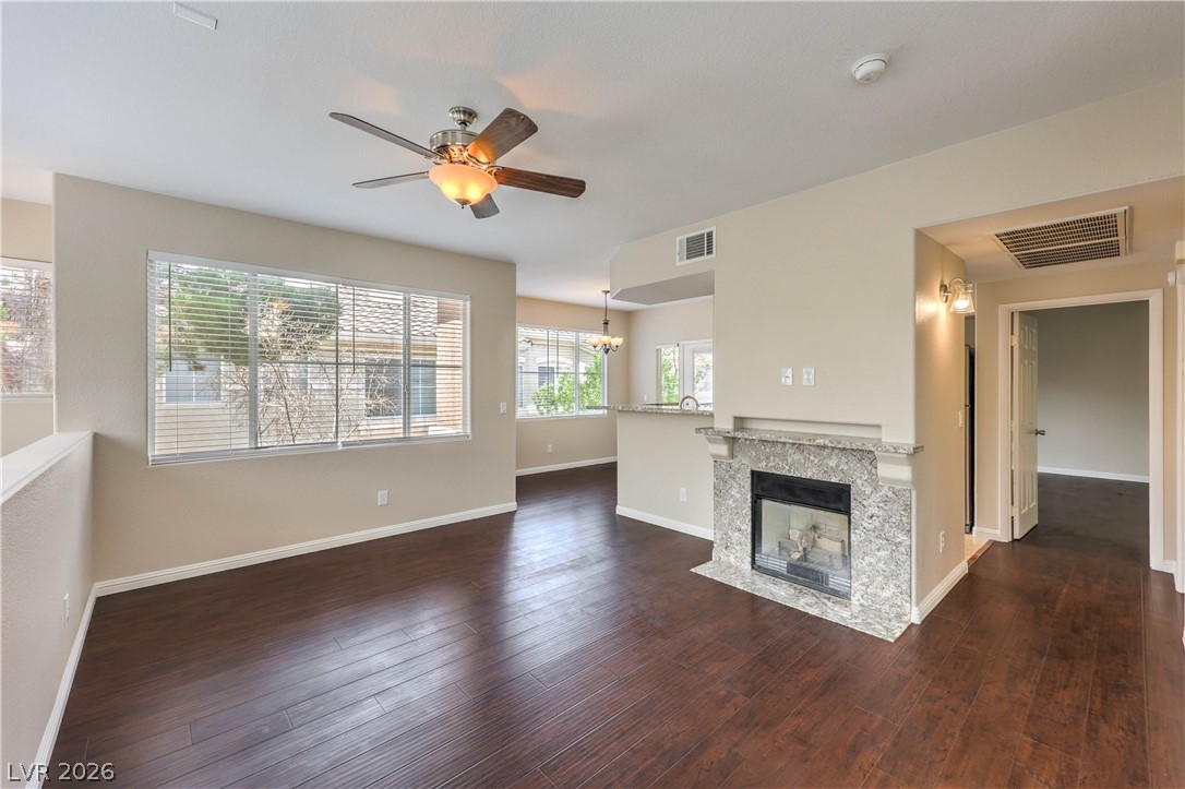 9050 West Warm Springs Road, Unit 2033 Las Vegas, NV 89148 - Photo 8 of 30 Lustrous hardwood floors extend throughout this open-concept living space, featuring a cozy fireplace.