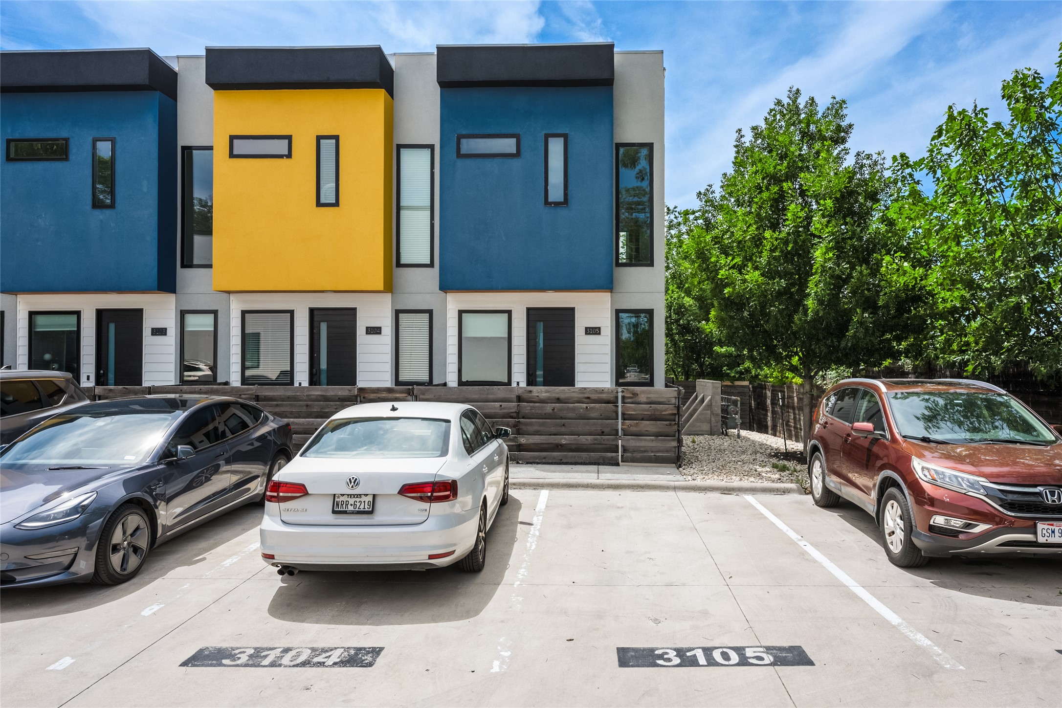 Modern multi-level townhome exteriors featuring vibrant blue and yellow facades