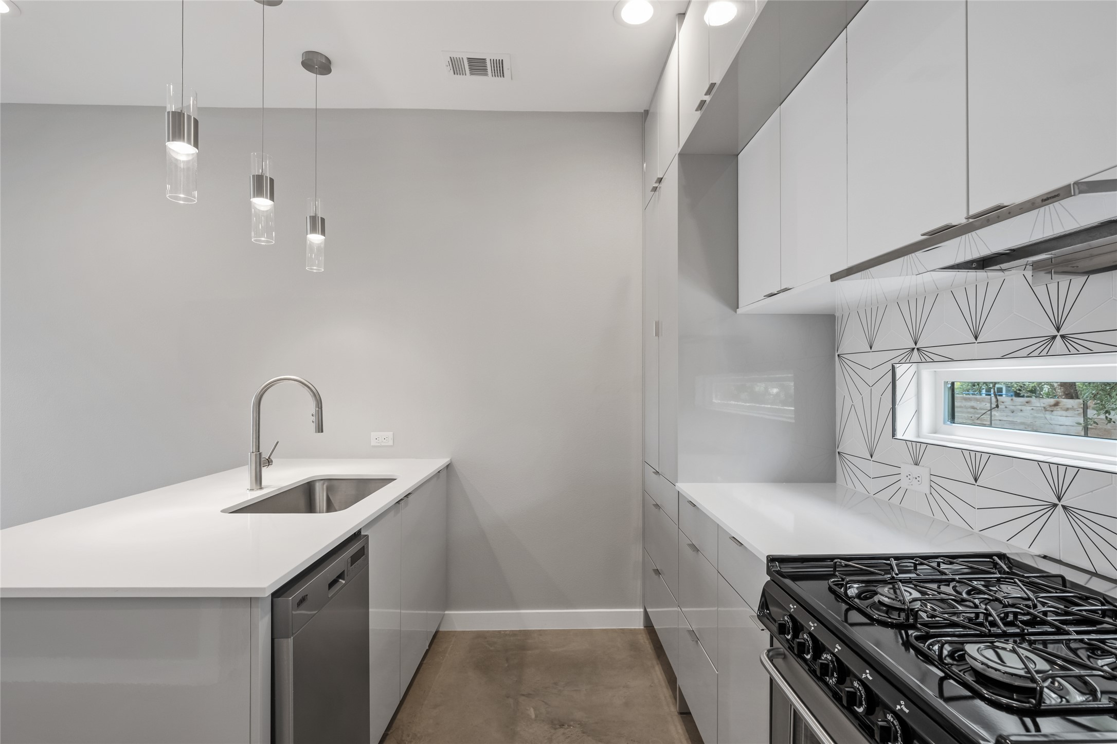 2108 Tillery Street, Unit 16 Austin, TX 78723 - Photo 5 of 15 Contemporary kitchen featuring white flat-panel cabinetry, a stainless steel sink, and a gas range