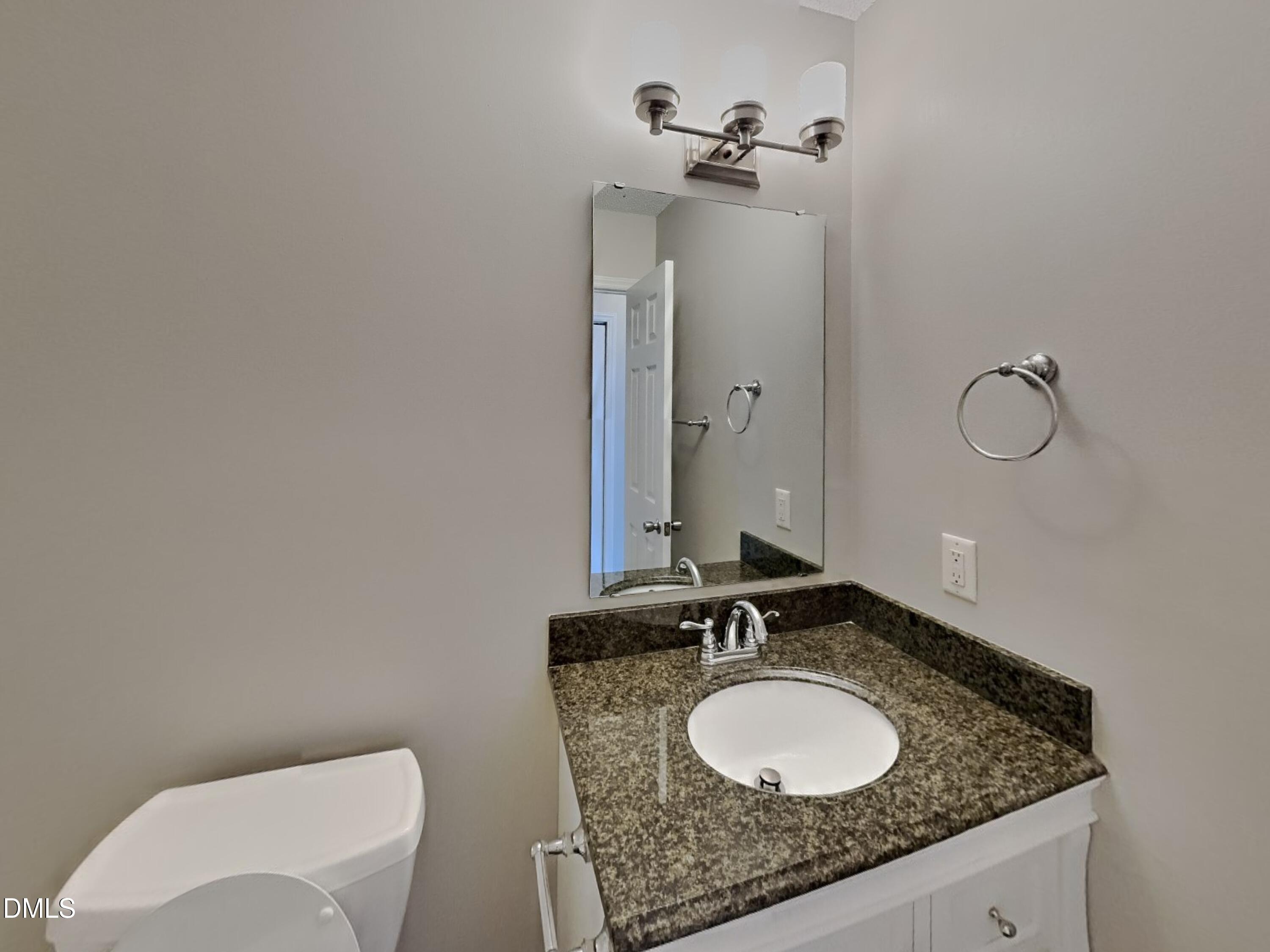5516 Wilhagan Court Raleigh, NC 27616 - Photo 14 of 16 a bathroom with a granite countertop sink and a mirror