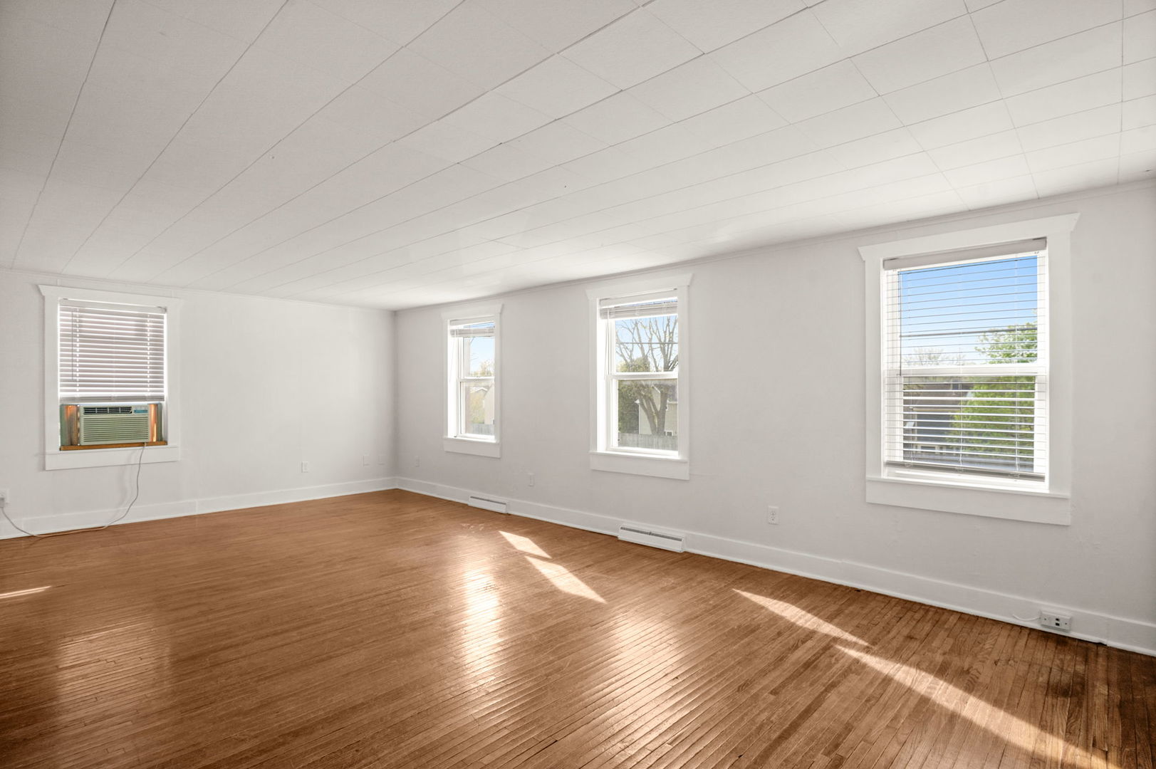 827 East Wilson Street, Unit B Batavia, IL 60510 - Photo 4 of 17 a view of an empty room with wooden floor and a window