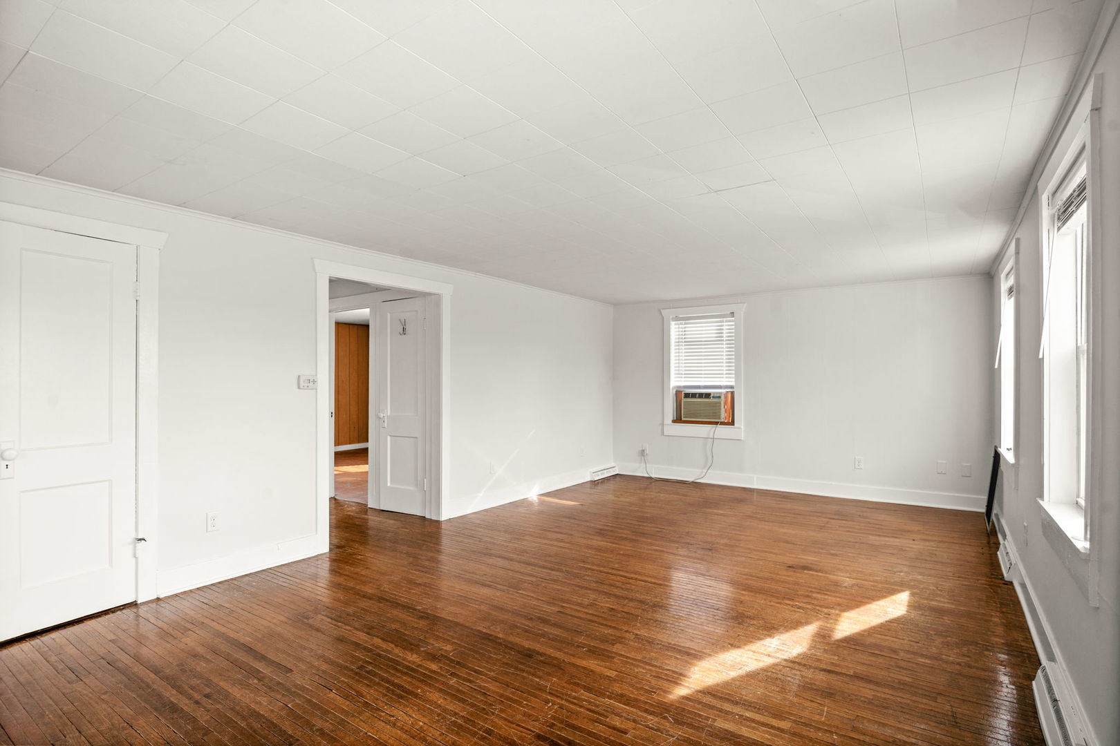 827 East Wilson Street, Unit B Batavia, IL 60510 - Photo 5 of 17 an empty room with wooden floor and windows