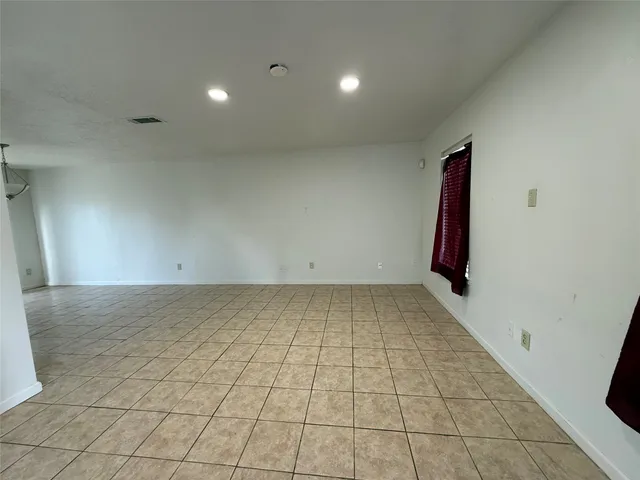 an empty room with white walls and tiles