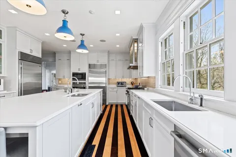 a large white kitchen with a large window