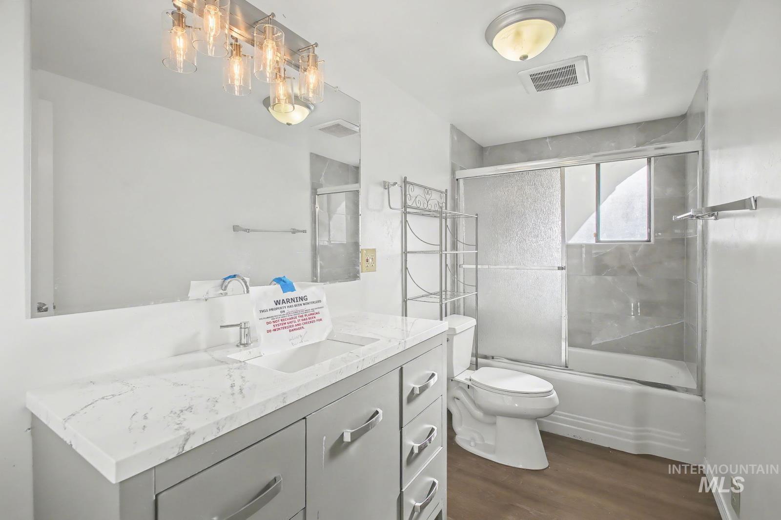 1830 Columbia Street Pomeroy, WA 99347 - Photo 14 of 28 Bathroom with vanity, dark wood finished floors, and bath / shower combo with glass door