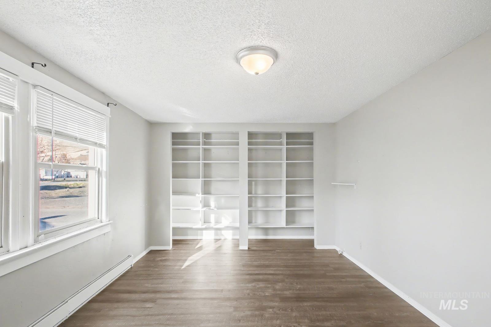 1830 Columbia Street Pomeroy, WA 99347 - Photo 15 of 28 Spare room with a textured ceiling, baseboard heating, and dark wood-style flooring