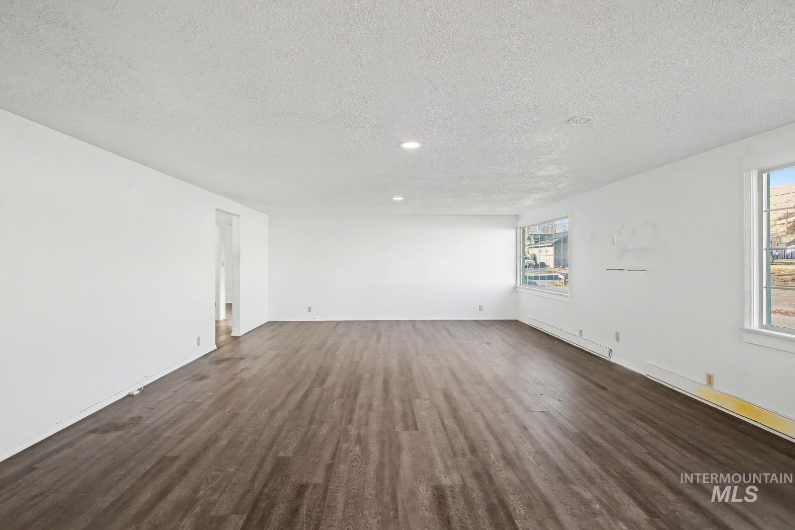 1830 Columbia Street Pomeroy, WA 99347 - Photo 4 of 28 Empty room featuring dark wood-type flooring, a textured ceiling, baseboard heating, and recessed lighting