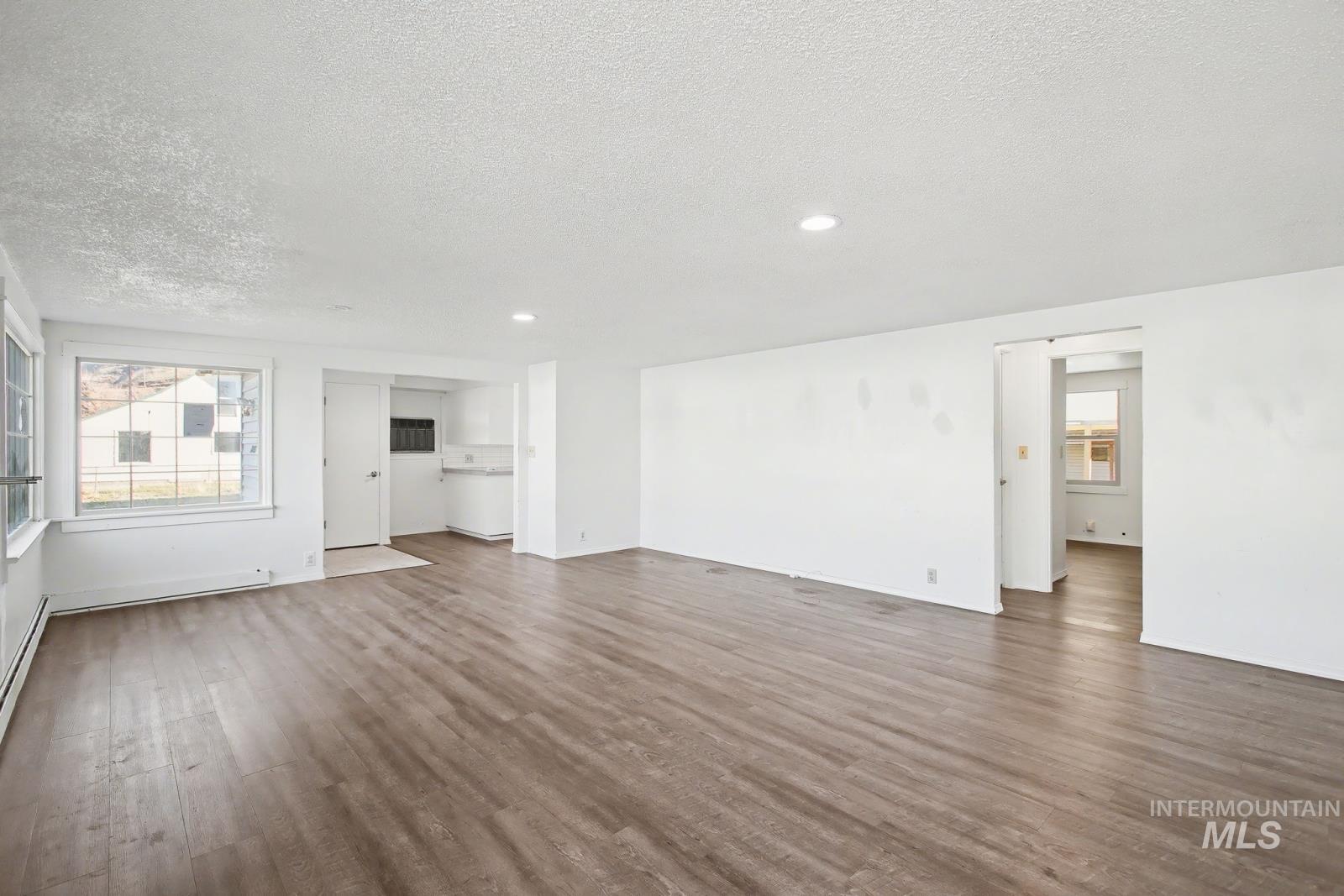 1830 Columbia Street Pomeroy, WA 99347 - Photo 6 of 28 Unfurnished living room featuring a textured ceiling, dark wood-style floors, and recessed lighting