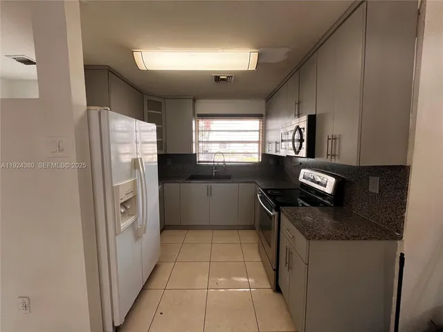 a kitchen with a refrigerator and a stove