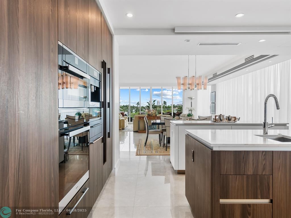 353 Sunset Drive, Unit 401 Fort Lauderdale, FL 33301 - Photo 19 of 43 a kitchen with kitchen island a counter top space a sink stainless steel appliances and cabinets