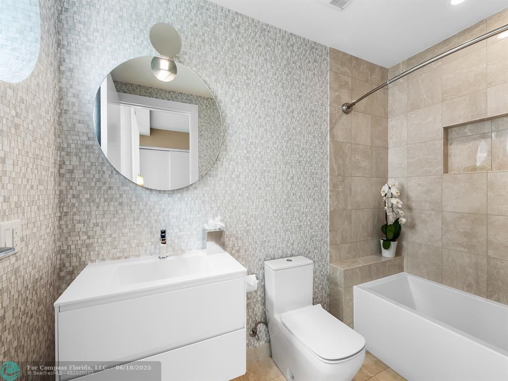 353 Sunset Drive, Unit 401 Fort Lauderdale, FL 33301 - Photo 33 of 43 a white toilet sitting next to a bathroom sink and tub