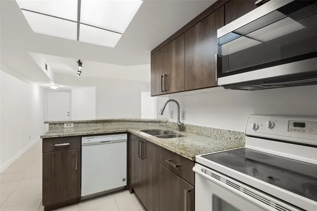 a kitchen with stainless steel appliances granite countertop a sink and cabinets