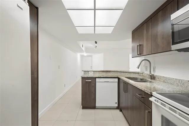 a view of a kitchen with a sink and a chandelier fan