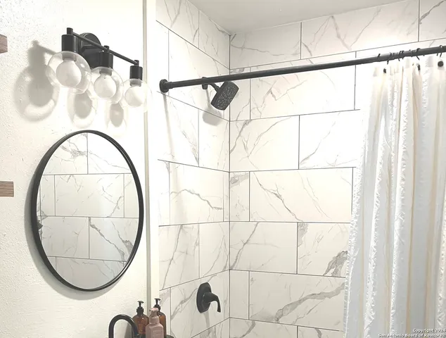 a bathroom with a glass shower and a mirror of it