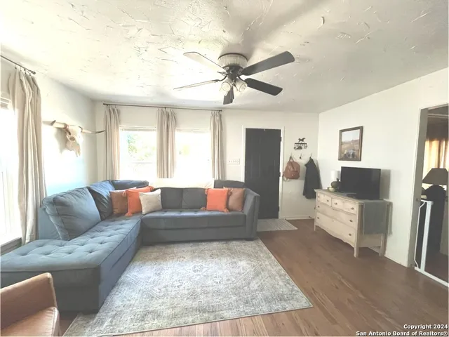 a living room with furniture and a wooden floor