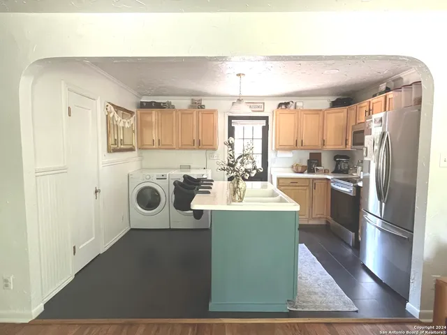 a kitchen with a refrigerator sink and white cabinets
