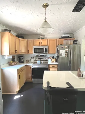 a kitchen with stainless steel appliances kitchen island granite countertop a sink refrigerator and cabinets