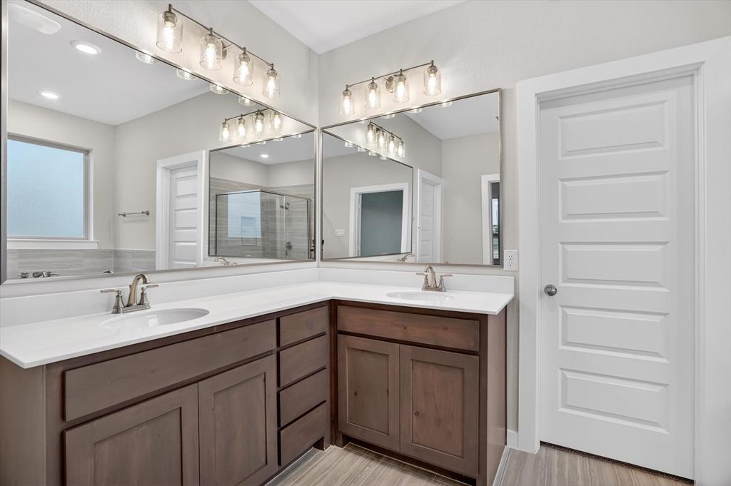 321 Skeen Peak Springtown, TX 76082 - Photo 36 of 37 Bathroom featuring a double vanity with wood cabinetry, white countertops, and undermount sinks