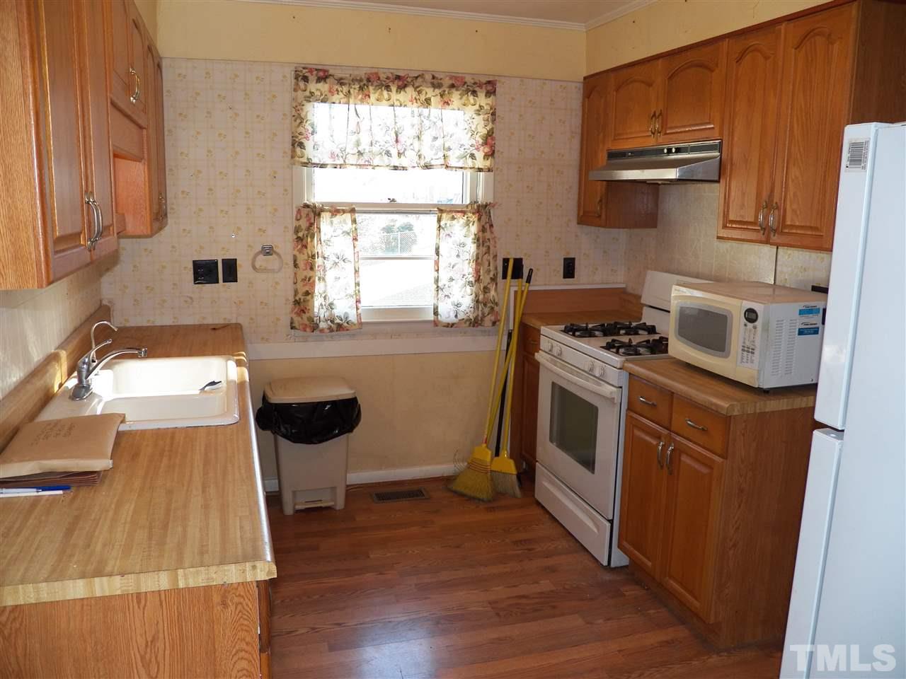 124 East Rowan Street Raleigh, NC 27609 - Photo 3 of 18 a kitchen with a stove a sink and a microwave