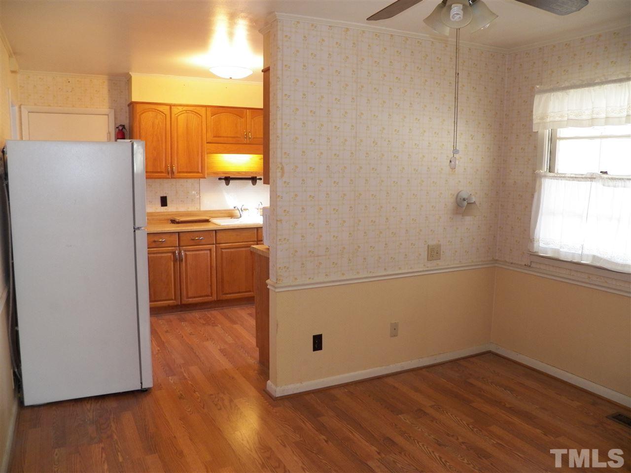 124 East Rowan Street Raleigh, NC 27609 - Photo 4 of 18 an empty room with wooden floor cabinet and windows