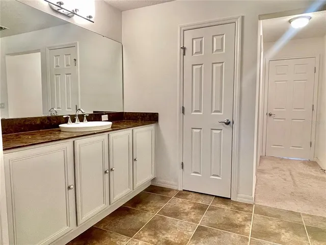 a bathroom with a tub shower and checkered floor