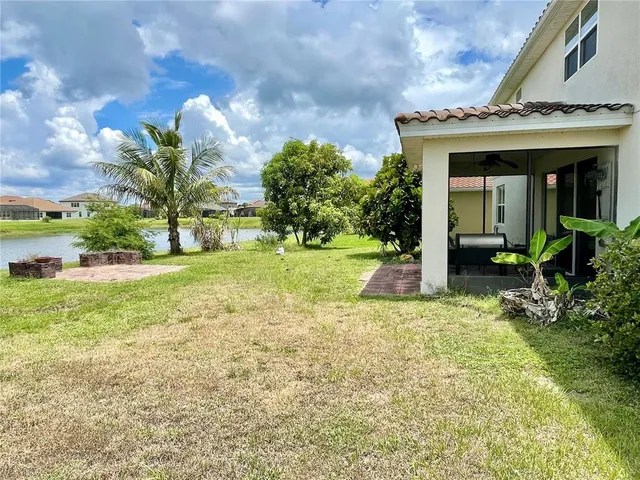 a view of a house with backyard and trees