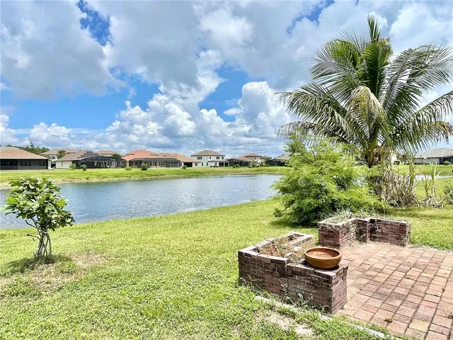 an aerial view of a house with a garden and lake view