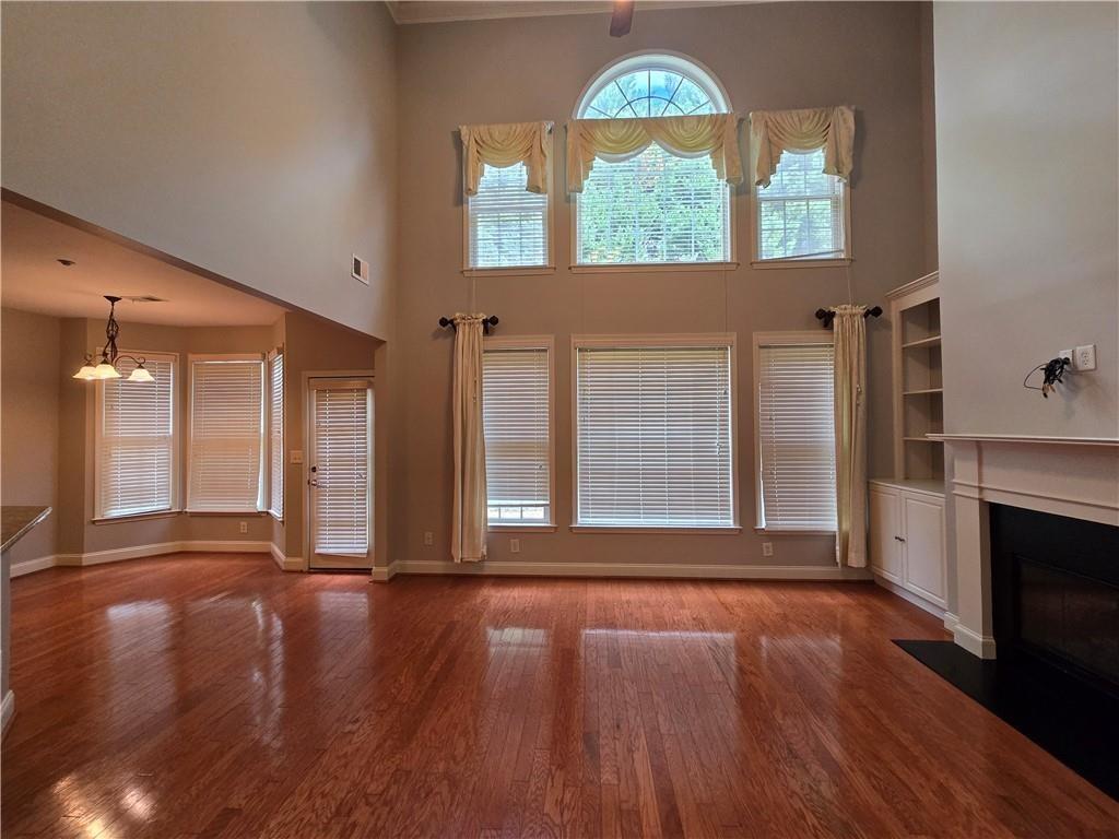624 Maple Grove Way Marietta, GA 30066 - Photo 3 of 27 an empty room with wooden floor fireplace and windows
