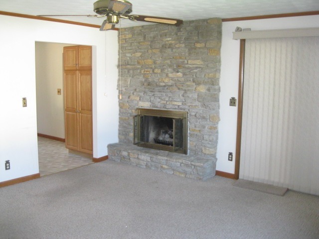 215 Linder Lane Rochelle, IL 61068 - Photo 4 of 19 an empty room with a fireplace and chandelier fan