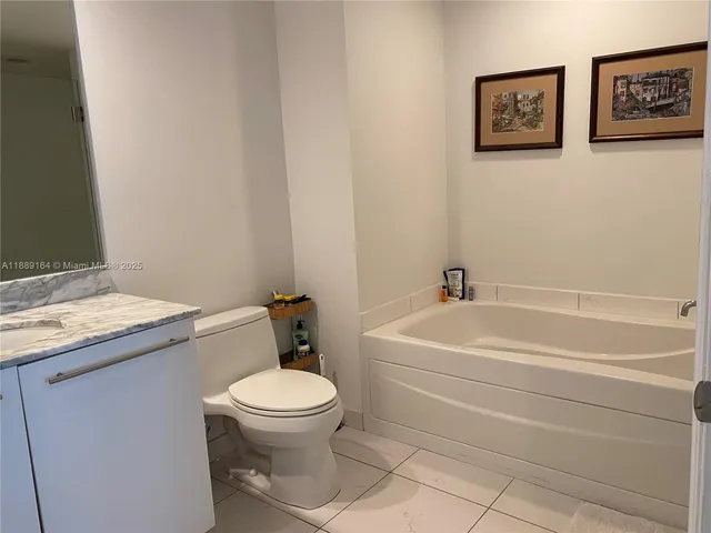 a white toilet sitting next to a bathroom sink and tub
