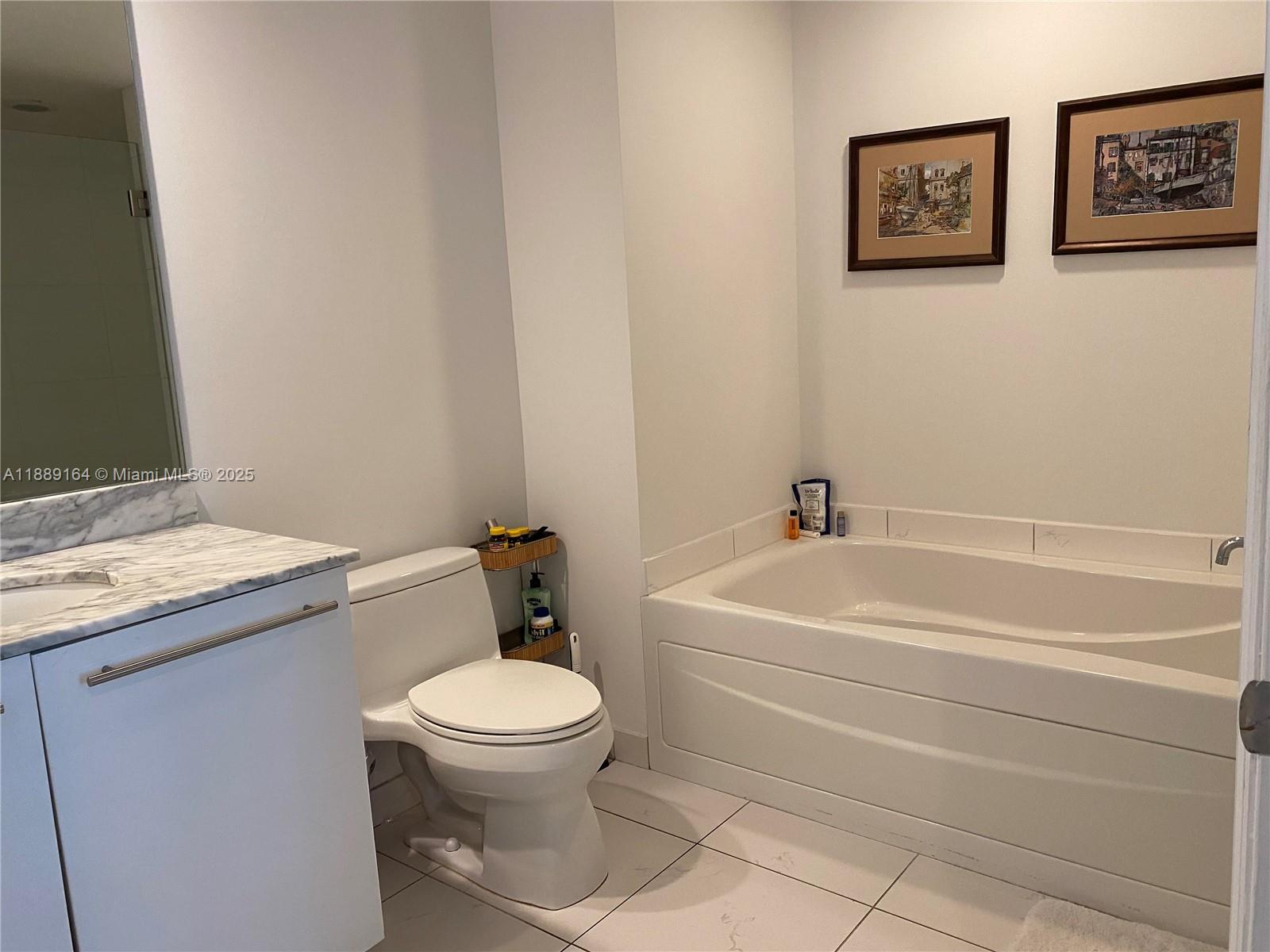 500 Brickell Avenue, Unit 1908 Miami, FL 33131 - Photo 6 of 13 a white toilet sitting next to a bathroom sink and tub