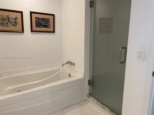 a spacious bathroom with a bathtub and shower