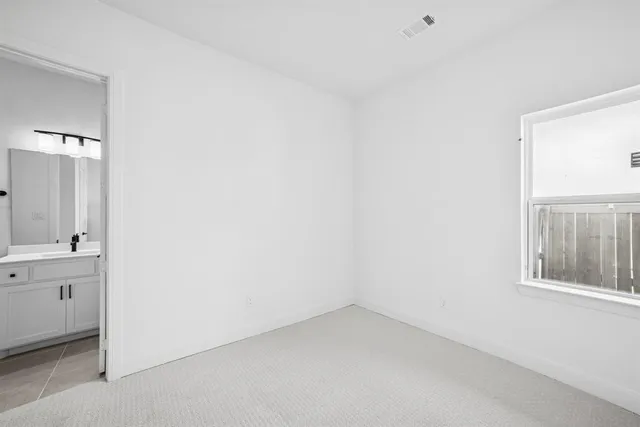 a kitchen with stainless steel appliances granite countertop a sink a stove a refrigerator and white cabinets with wooden floor