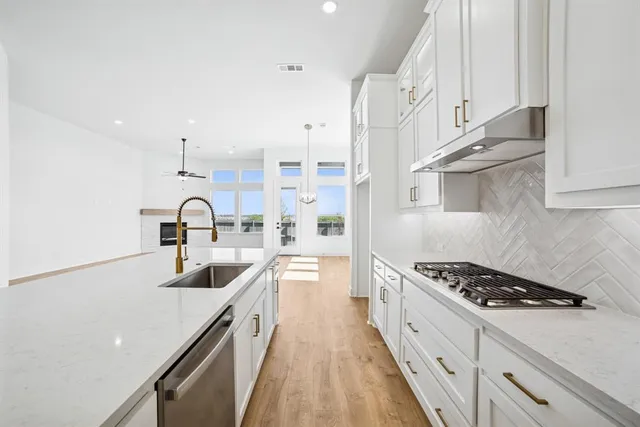 a view of a kitchen with kitchen island stainless steel appliances refrigerator stove and microwave